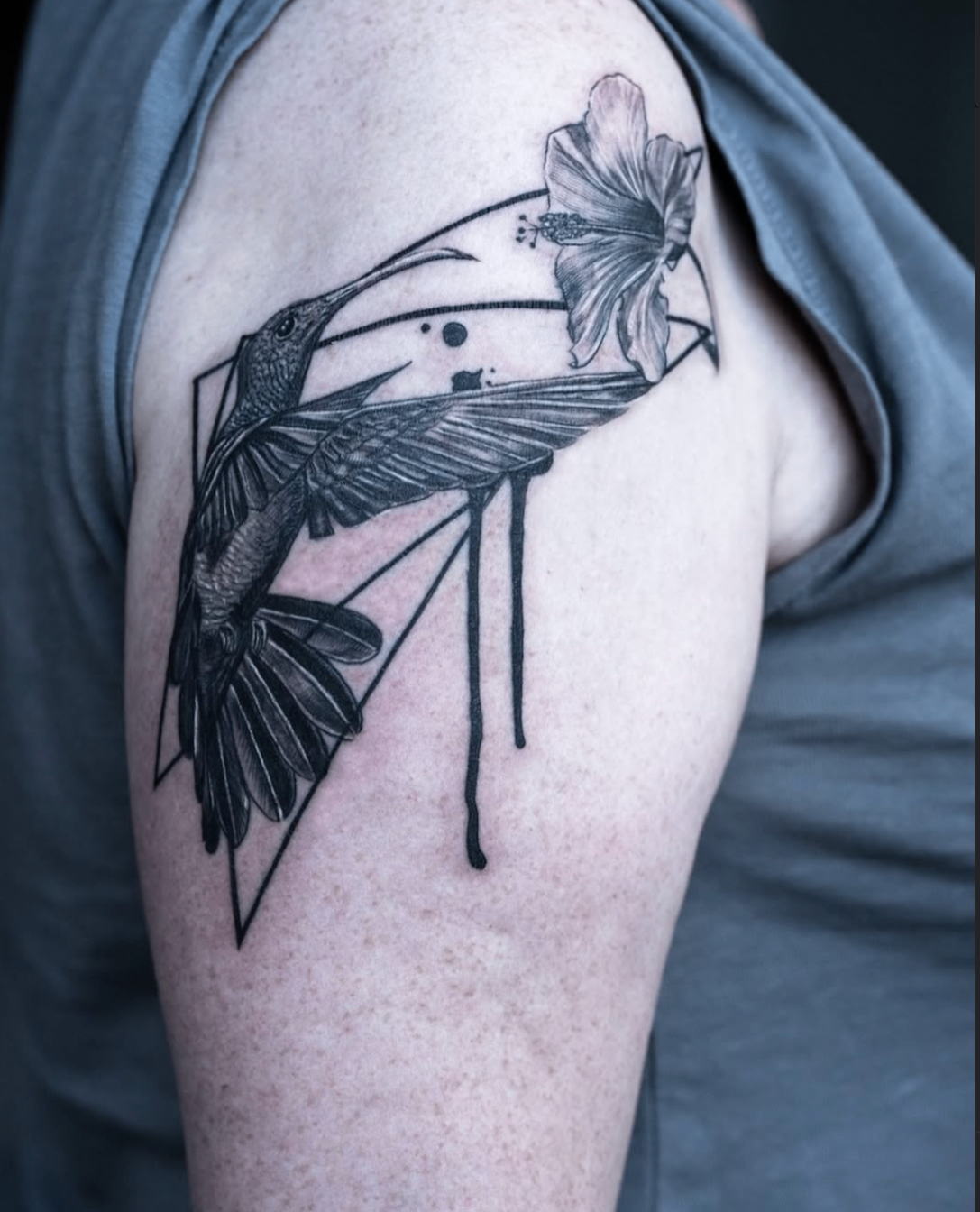 Close-up hummingbird and hibiscus geometric shoulder tattoo