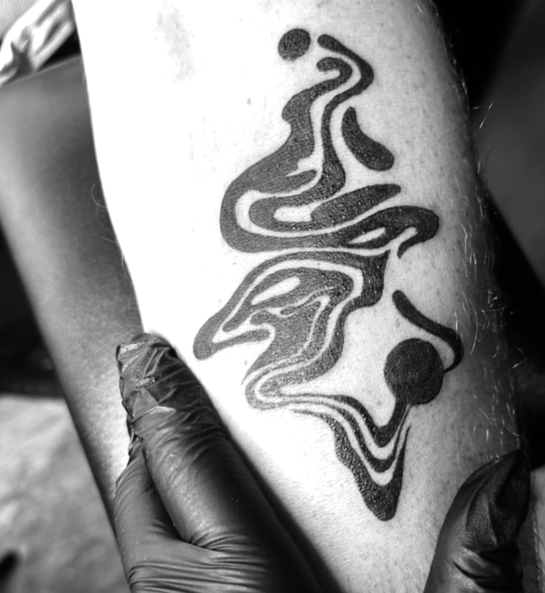 Abstract flowing blackwork ornament on thigh