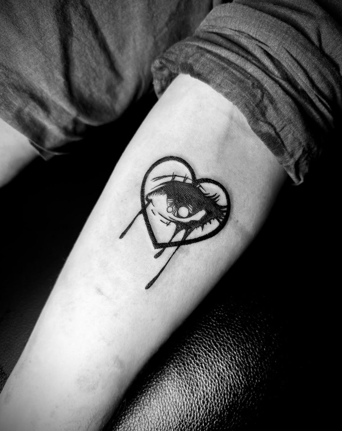 Bold blackwork heart with eye inside on forearm