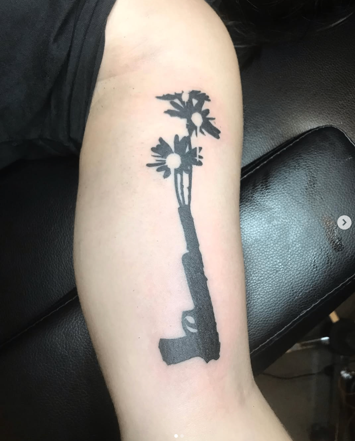Revolver with daisies blooming from the barrel