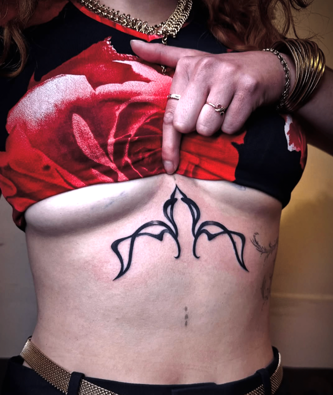 Ornamental sternum tattoo with sharp black linework