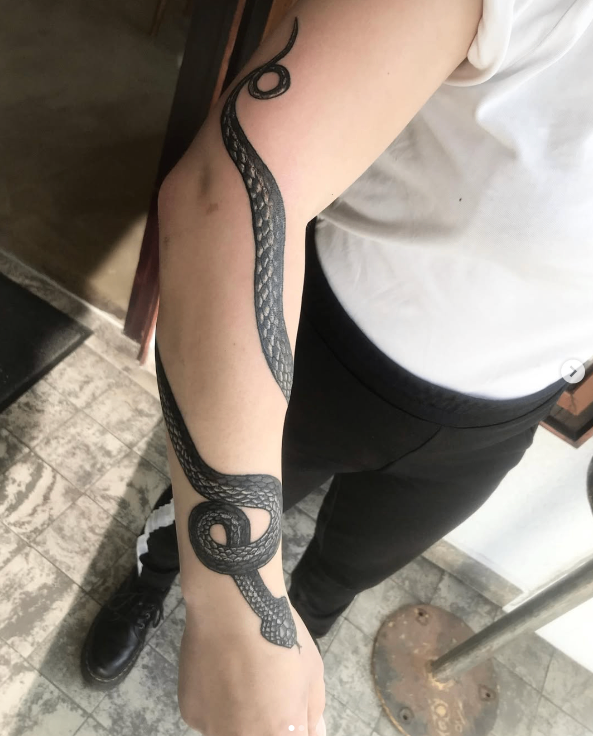 Snake wrapping from upper arm to hand