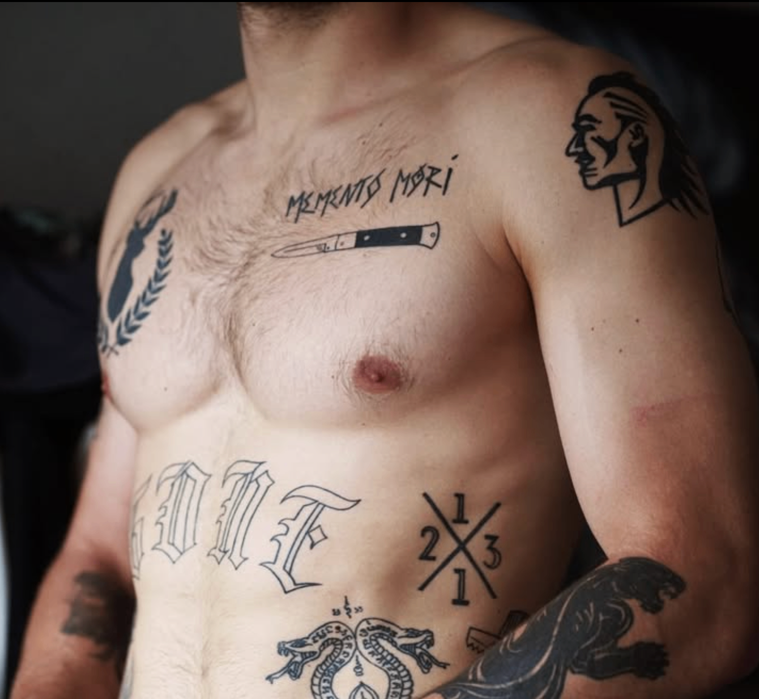 Minimal chest lettering and small symbolic tattoos
